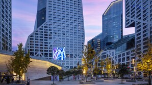 A modern urban plaza with high-rise buildings, including a prominent building with 'ASCOTT' signage.