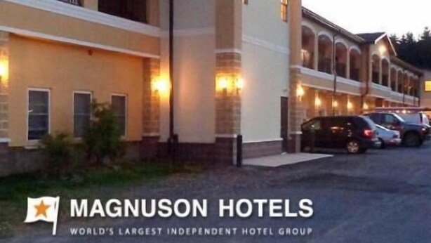 A hotel with a row of rooms, a covered outdoor area, and a parking lot. - Budget Inn Williamsport (Williamsport)