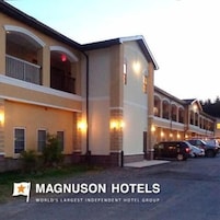 Un hotel con varias habitaciones, un espacio exterior cubierto y un estacionamiento.