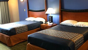 A hotel room with two beds, a nightstand, a lamp, and a window with curtains. - Budget Inn Williamsport (Williamsport)