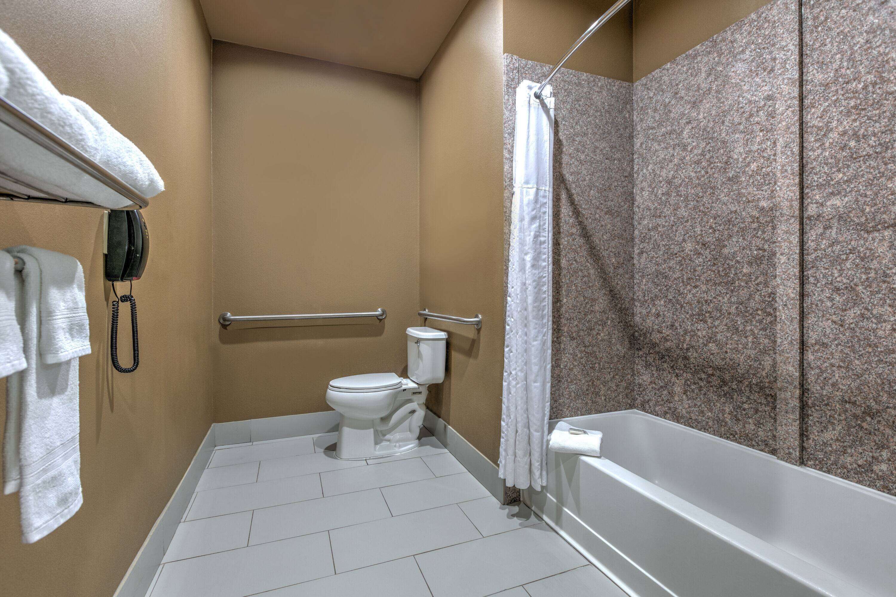 Une salle de bain comprenant des toilettes, une douche et une baignoire.