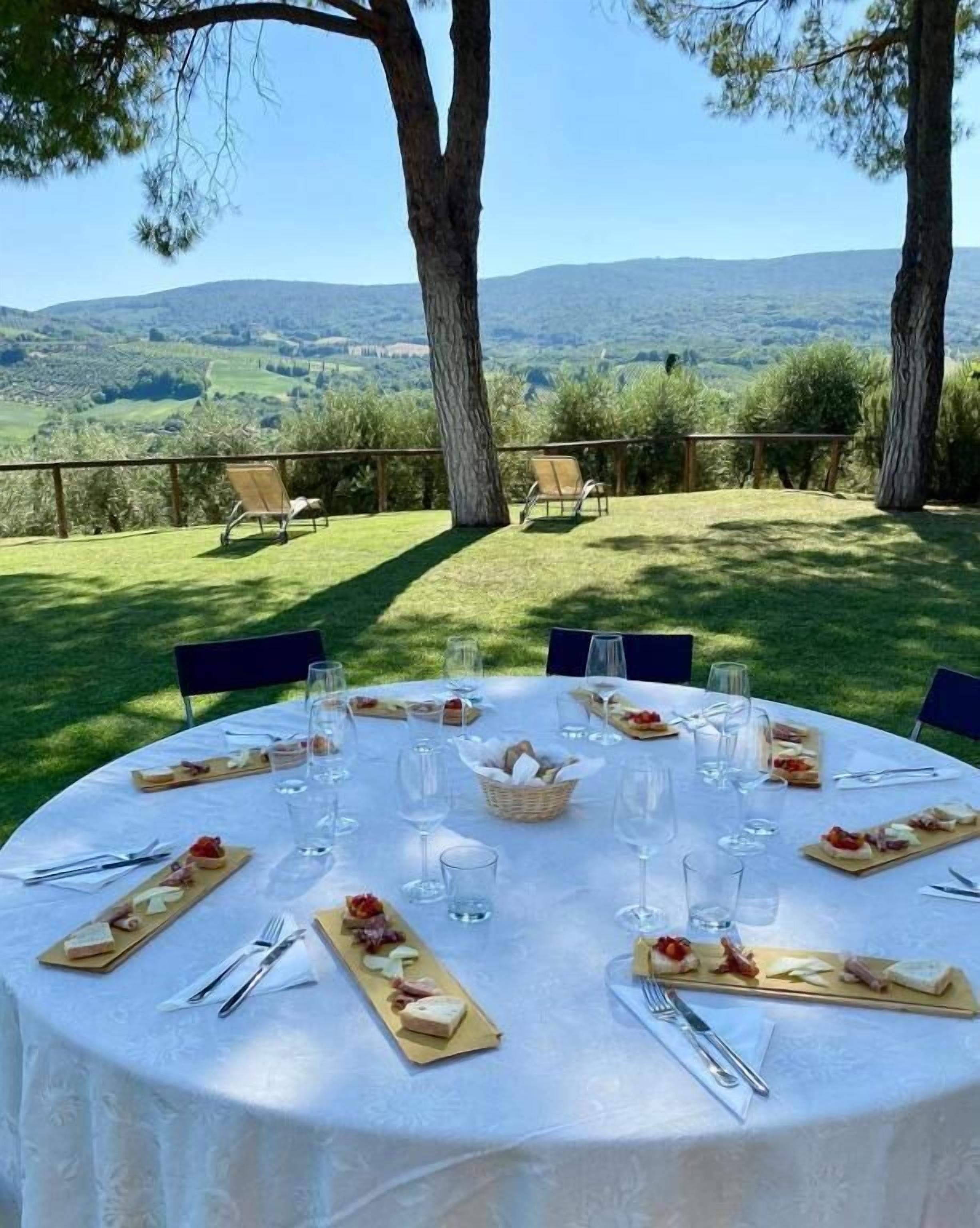 Un área de comedor al aire libre con una mesa dispuesta para una comida, con vistas a un paisaje pintoresco.