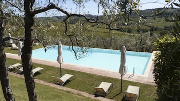 Una piscina al aire libre de temporada, una piscina infinita, sombrillas