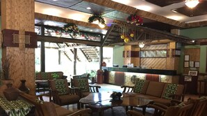 A cozy lobby with wooden furniture, a reception desk, and a view of the outdoors. - Dao Diamond Hotel (Tagbilaran)