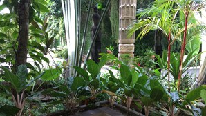 A garden with various plants and a stone structure. - Dao Diamond Hotel (Tagbilaran)