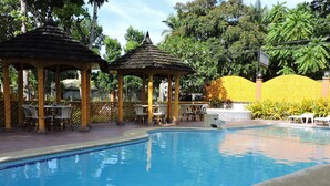 A swimming pool with a tiled edge, surrounded by wooden gazebos and outdoor seating. - Dao Diamond Hotel (Tagbilaran)