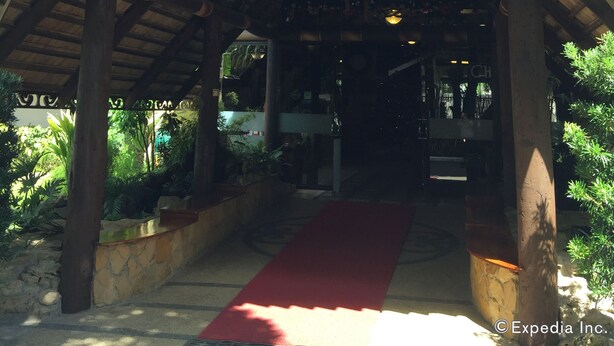 A covered entrance with a red carpet, wooden pillars, and a decorative ceiling. - Dao Diamond Hotel (Tagbilaran)