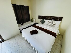 Habitación de hotel con dos camas, una cortina oscura y un cabecero con detalles decorativos.