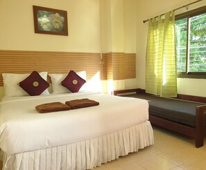 Habitación de hotel con una cama grande, dos almohadas, una mesita de noche, una ventana con cortinas y un cuadro en la pared.