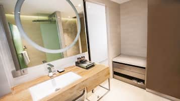 A modern bathroom with a wooden vanity, a large mirror, and a built-in shower.
