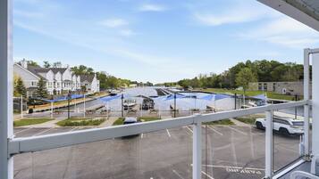 A view from a window overlooking a marina with boats, a parking lot, and residential buildings in the background.