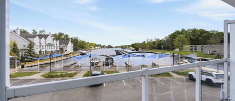 A view from a window overlooking a marina with boats, a parking lot, and residential buildings in the background.