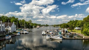 Una marina con barcos amarrados a lo largo de un canal, rodeada de edificios residenciales y vegetación.
