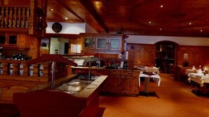 A wooden interior with a bar area, a counter, and a dining space. - Hotel Alexander (Basel)