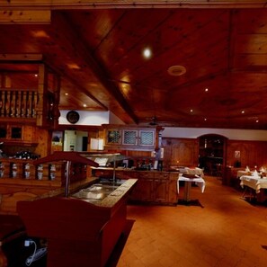 A wooden interior with a bar area, a counter, and a dining space. - Hotel Alexander (Basel)