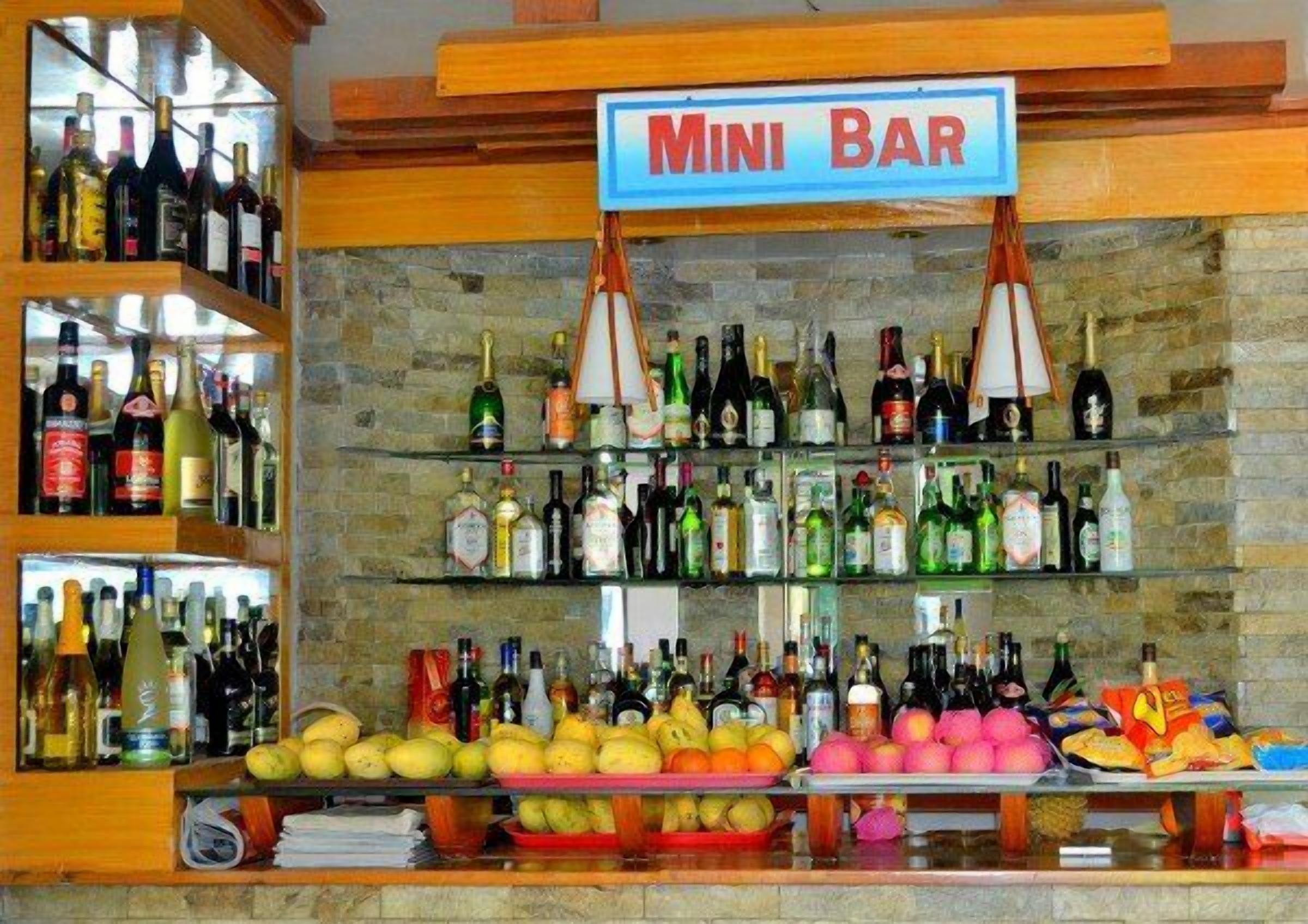 A mini bar with shelves of liquor bottles and a variety of fruits.