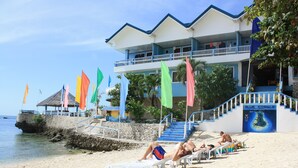 A beachside hotel with a balcony, a staircase leading to the upper floor, and a view of the sea. - Blue Corals Beach Resort (Daanbantayan)