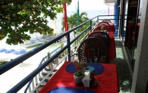 A balcony with a view of the beach, outdoor seating with umbrellas, and a railing. - Blue Corals Beach Resort (Daanbantayan)