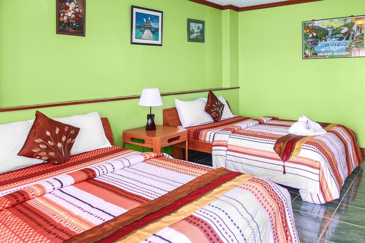Una habitación de hotel con dos camas, una mesita de noche y una lámpara.
