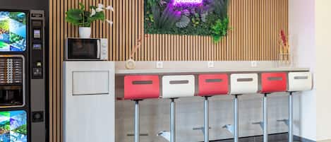 Zona de bar con un letrero de neón, un microondas y una máquina expendedora.
