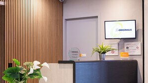 A reception desk with a wooden panel wall, a potted plant, and a monitor displaying 'The Originals ACCESS'. - The Originals ACCESS Tendance Hôtel (Andrezieux-Boutheon)