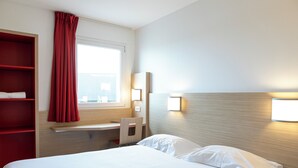 A hotel room with a bed, a desk, a chair, a red shelf, a window with curtains, and wall-mounted lights. - The Originals ACCESS Tendance Hôtel (Andrezieux-Boutheon)