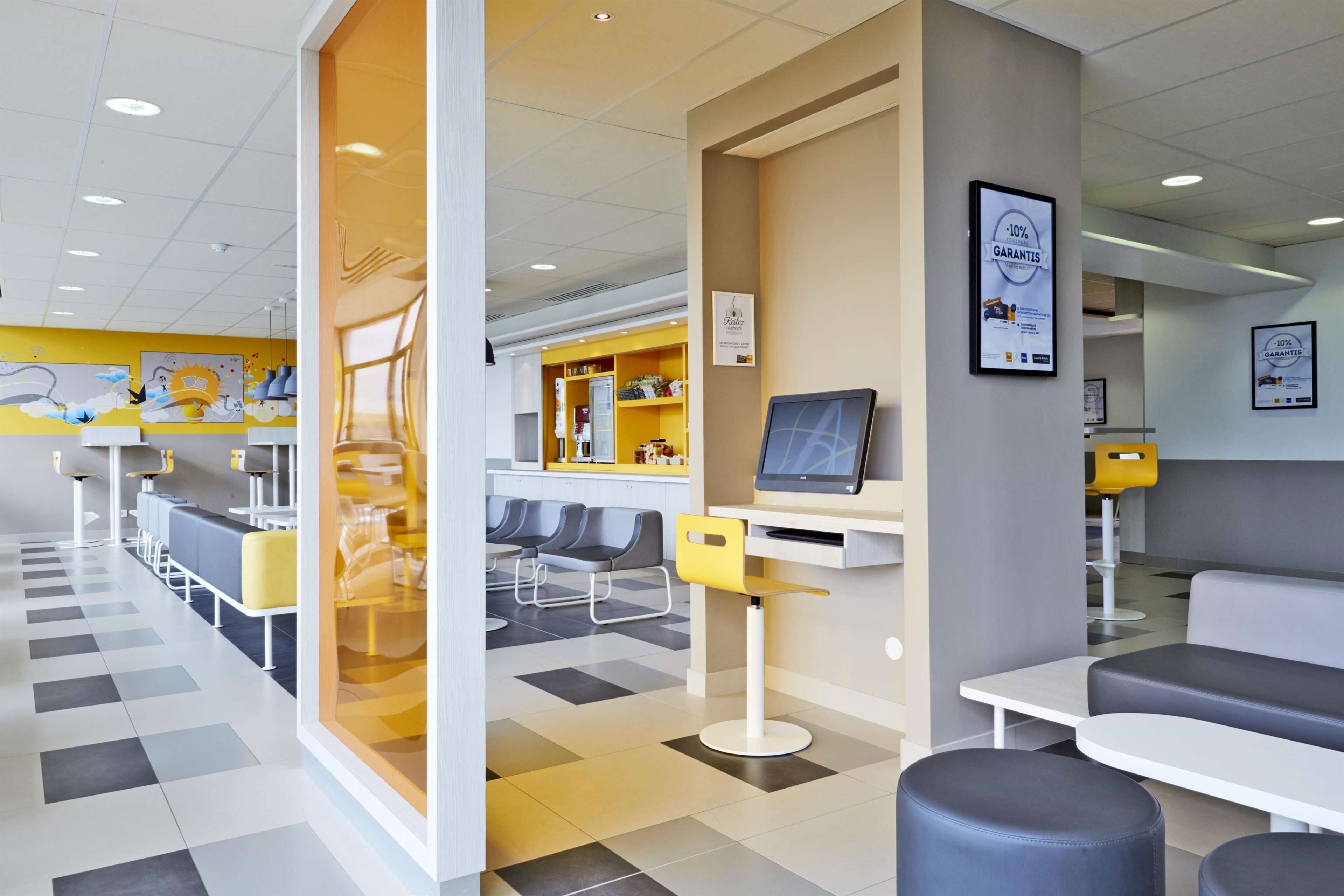 Un hall d’hôtel moderne comprenant un comptoir d’enregistrement, des espaces de détente et un bureau d’accueil.