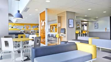 A modern cafe with seating areas, tables, and a counter.