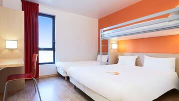 Habitación de hotel con dos camas, un escritorio, una silla y una ventana con cortinas.