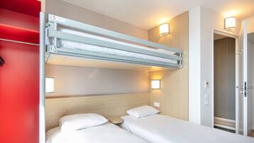 Ein Hotelzimmer mit zwei Betten, einer roten Wand und einer Deckenleuchte.