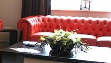 Una habitación con dos sofás de cuero rojo y una mesa de centro negra con un arreglo floral.