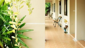 A hallway with a wooden ceiling and a plant with hanging leaves. - Garden Home Resort (Koh Samui)