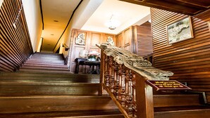 A wooden staircase with a handrail and a plaque at the bottom. - Sans Souci Samui (Koh Samui)
