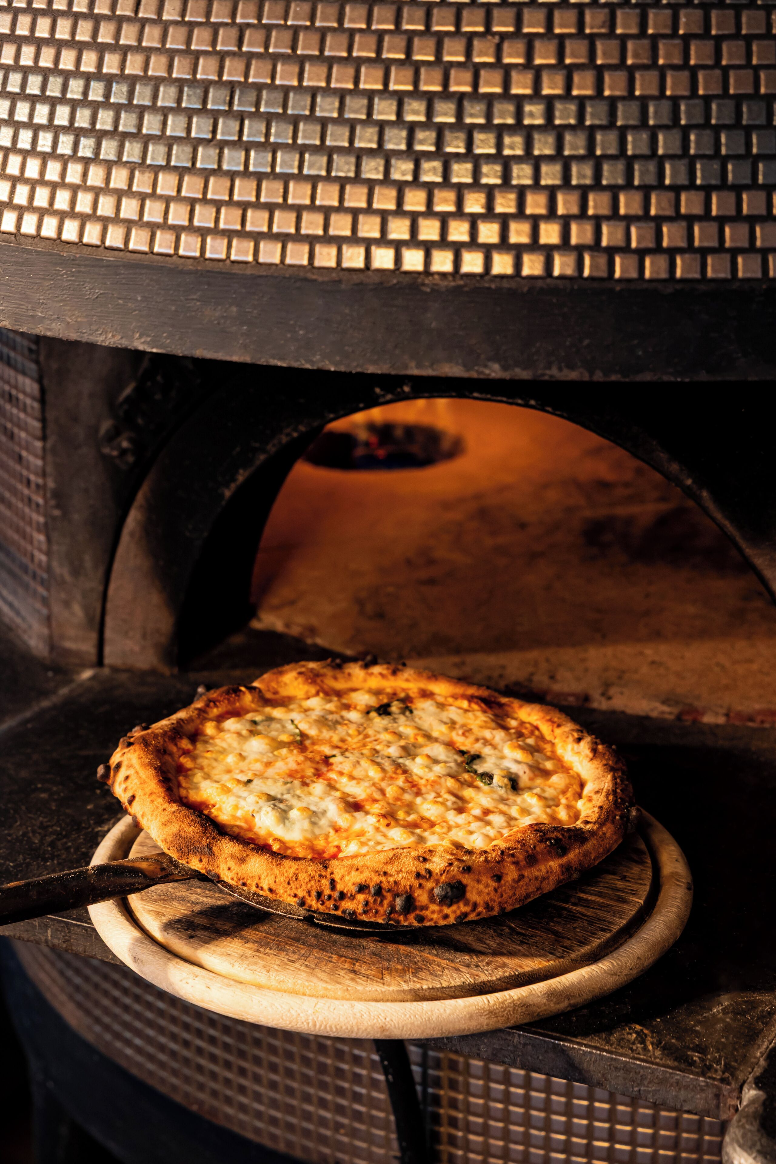 A pizza inside a brick oven.