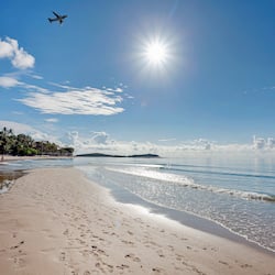 Praia particular, areia branca, espreguiçadeiras, guarda-sóis