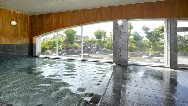 An indoor swimming pool with a view of a natural landscape through large windows. - Satsuma Resort Hotel (Satsuma)