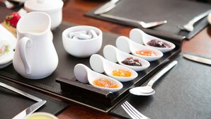 A table setting with a teapot, cups, and small bowls of condiments. - The Orchard (Newcastle West)