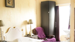 A hotel room with two beds, a wardrobe, a desk, and a lamp. - The Orchard (Newcastle West)