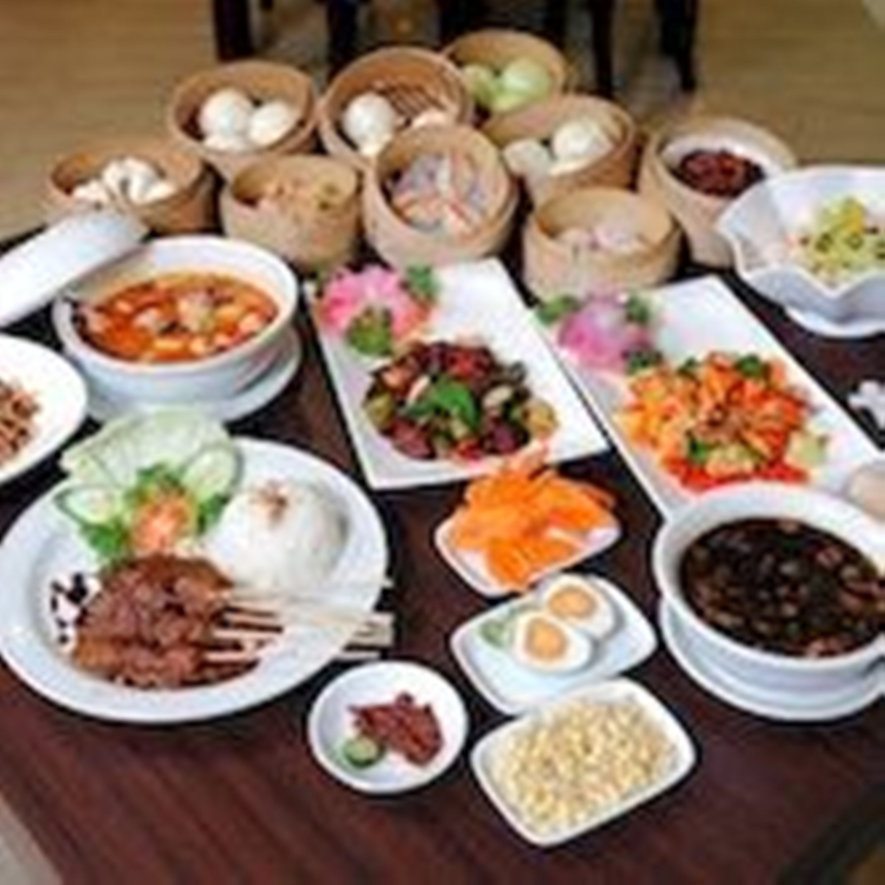 Une variété de plats sont disposés sur la table, notamment des bols de soupe, des assiettes de légumes et d’autres aliments.