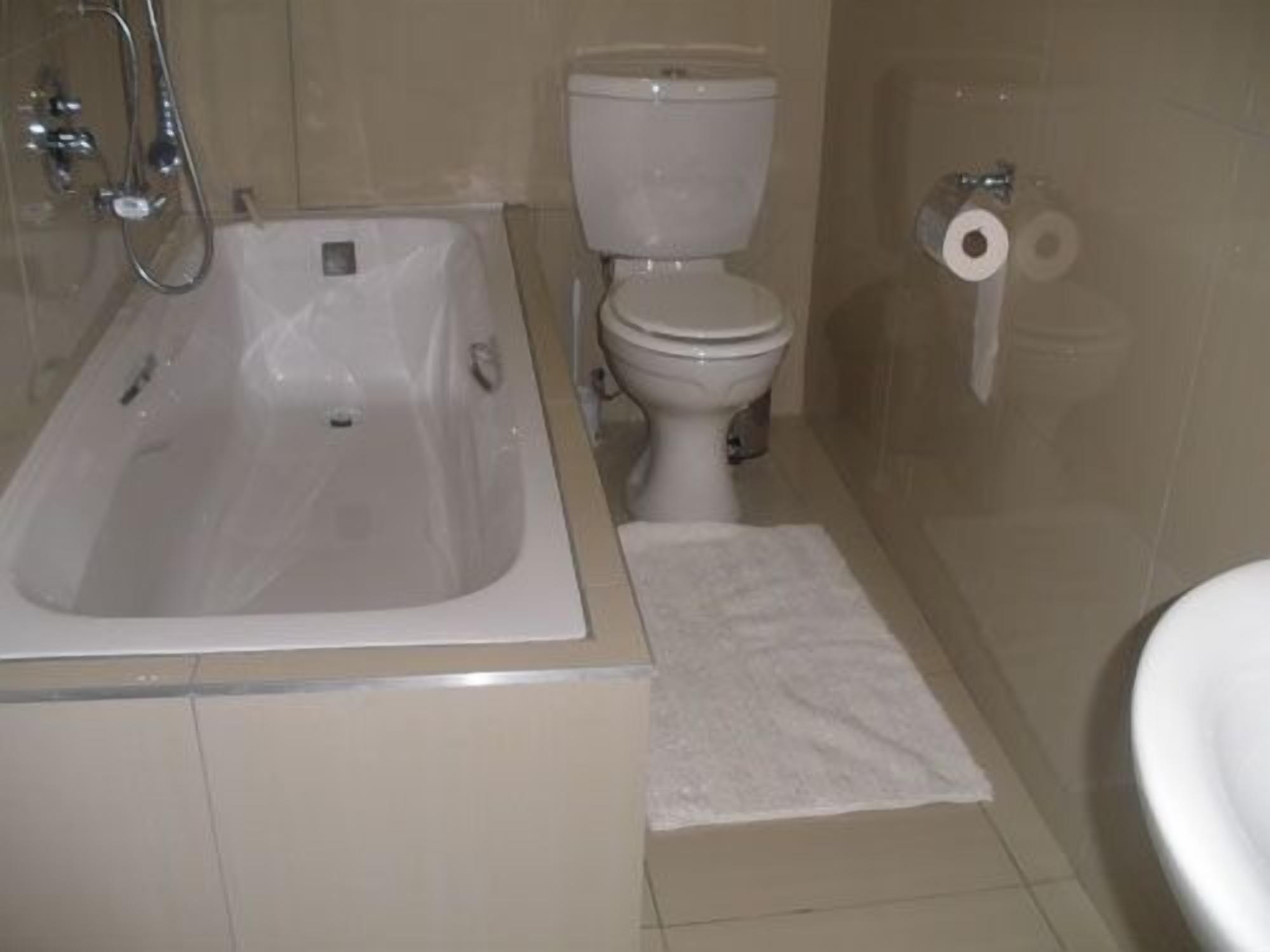 Un baño con bañera, inodoro y zona de ducha.
