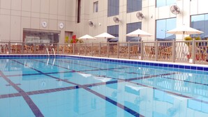 An indoor swimming pool with tiled walls and ceiling, surrounded by lounge chairs and umbrellas. - Ibis Yanbu Saudi Arabia (Yanbu)