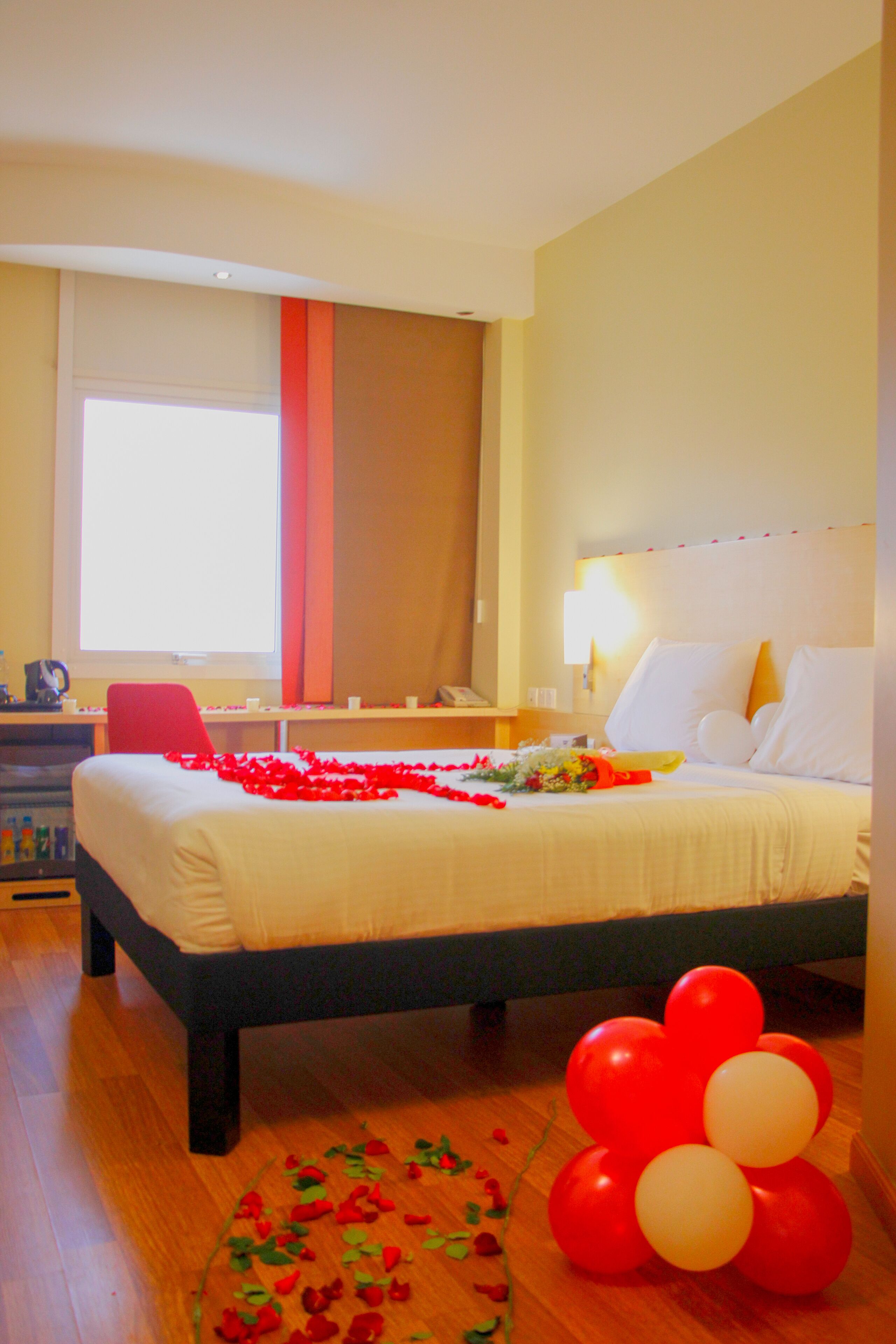 Una habitación de hotel con una cama, un escritorio, una silla y una ventana.