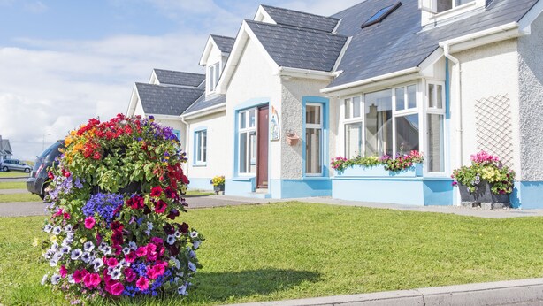 A row of houses with a well-maintained lawn and flower beds. - Portbeg Holiday Homes at Donegal Bay (Bundoran)