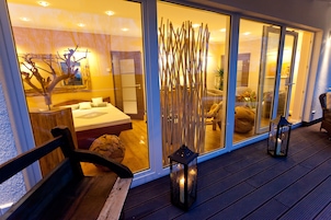 Ein modernes Interieur mit einer Holzbank, einer Glastür zu einem Schlafzimmer und einer Wandverzierung.
