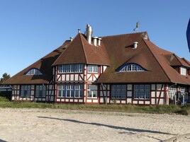 Ein traditionelles Fachwerkhäuschen mit mehreren Schornsteinen und großen Fenstern.