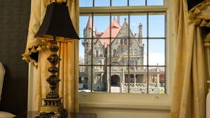 Una habitación con un ventanal grande, una lámpara y vistas a un edificio histórico.