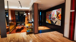 A modern living room with a wooden floor, a sofa, a coffee table, and a painting on the wall. - Esplendor by Wyndham Buenos Aires Plaza Francia (Buenos Aires)