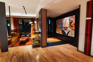 Un salón moderno con suelo de madera, un sofá, una mesa de centro y un cuadro en la pared.