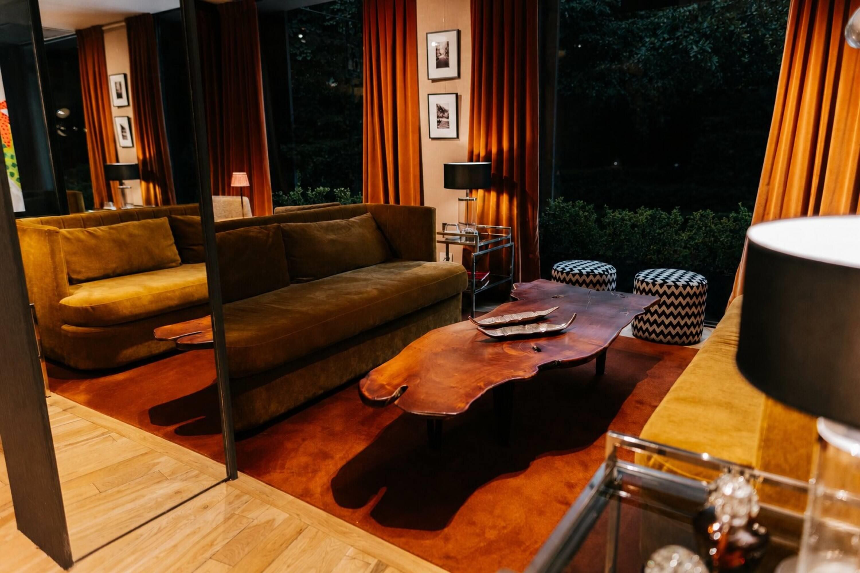 Un salon moderne avec un canapé, une table basse et deux poufs.
