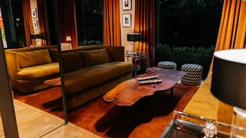 Un salon moderne avec un canapé, une table basse et deux poufs.